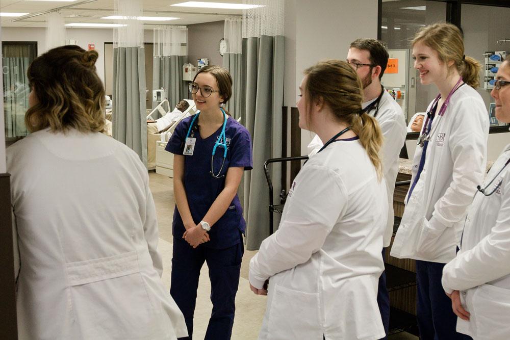 Group of nursing students stand in simulation lab