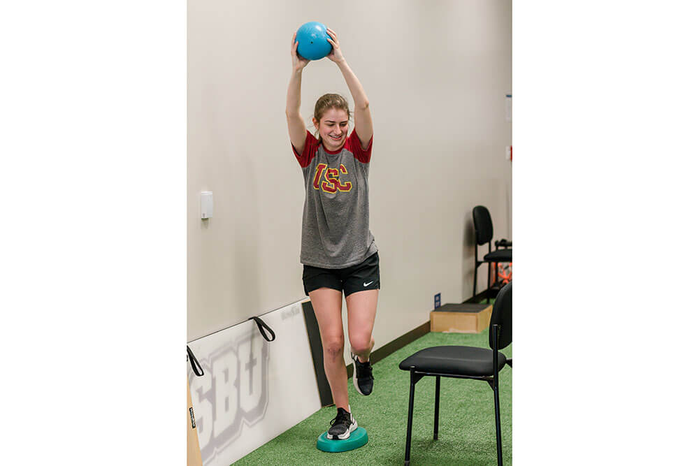 female patient uses exercise ball