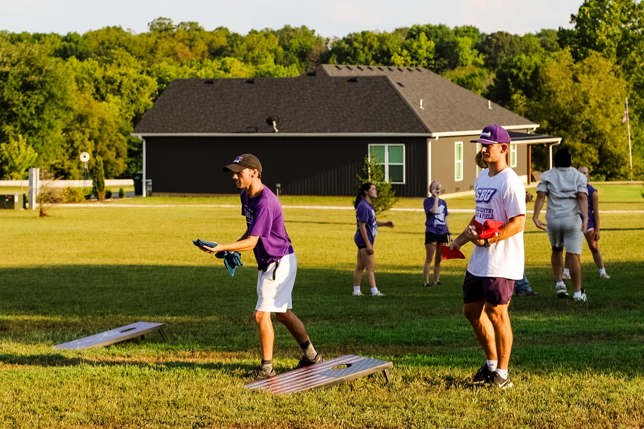 Male students playing corn hole during Welcome Week 2024.