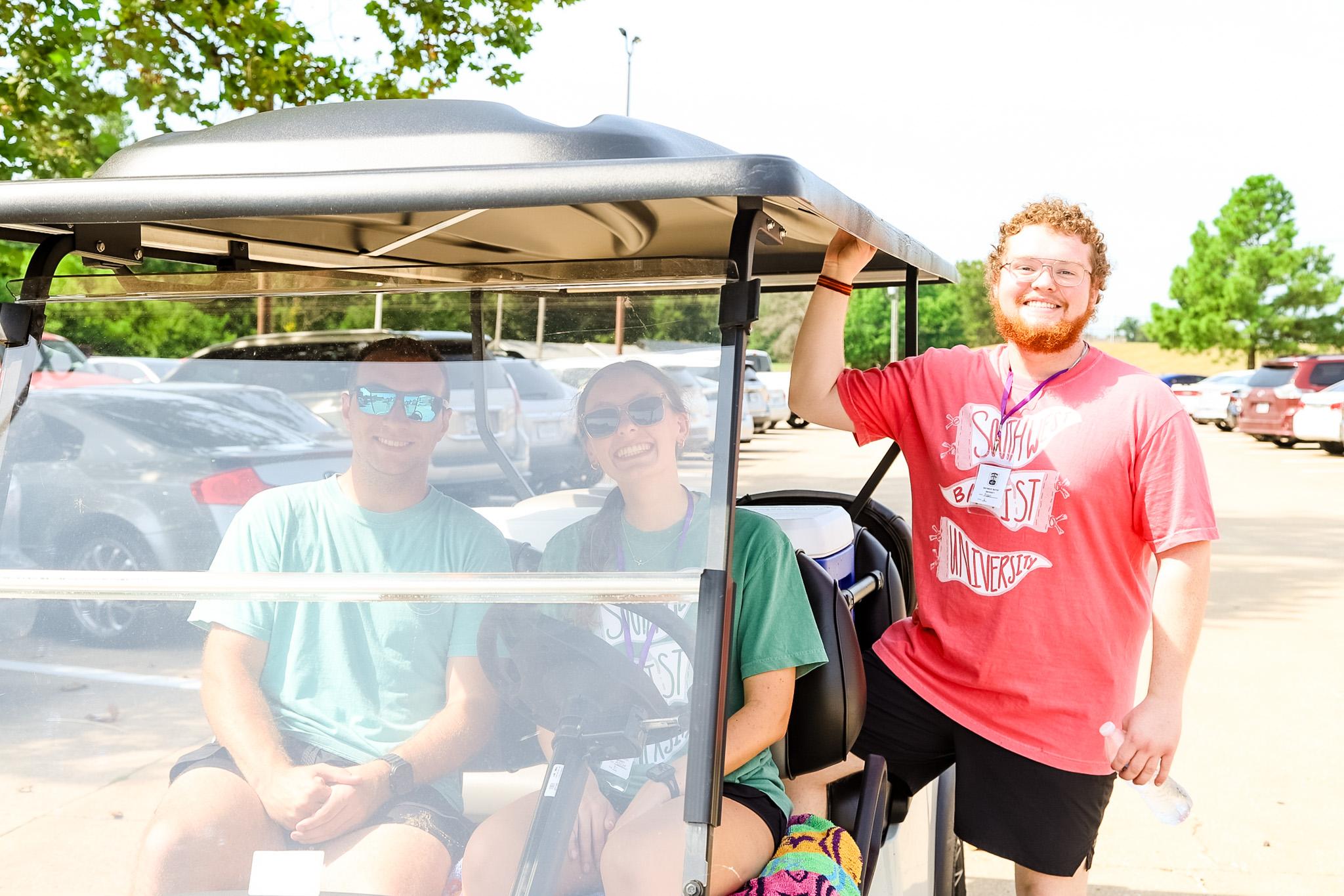 Students posing for photo with golf cart during Welcome Week 2024.