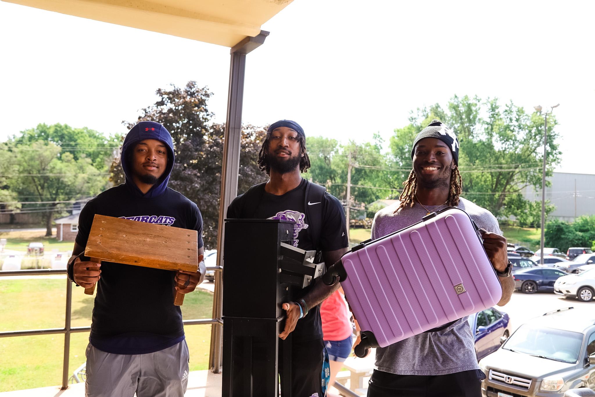 Football players helping carry furniture to the dorm during Welcome Week 2024.