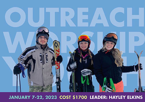 three students in ski gear stand in front of words outreach, worship, youth