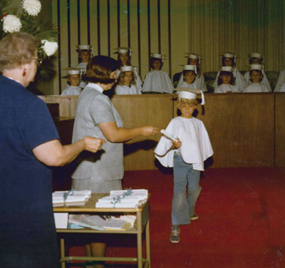 Janice Sartin hands a diploma to a kindergarten student in 1973.