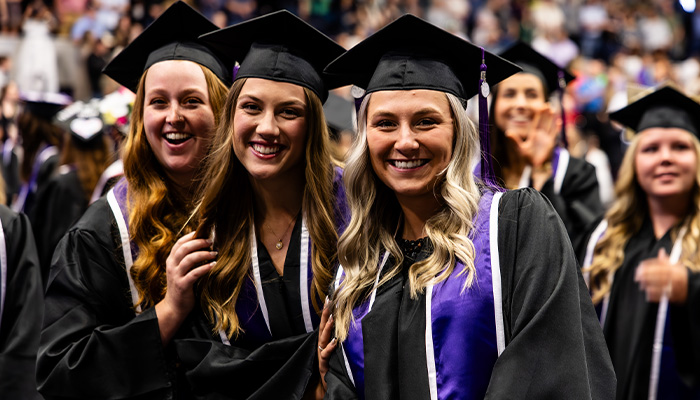 Girls grouped together at commencement smiling