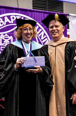 Julie Bryant posing with Troy Bethards during graduation recieving her award