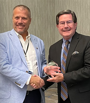 Dr. Kevin Schriver shaking hands and receiving award from representative