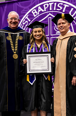Kara Kent, 2025 Life Beautfiful Award winning posing with President Melson at graduation