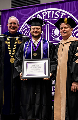 Logan Jeffrey, Life Beautiful award winner posing with President Melson on graduation day