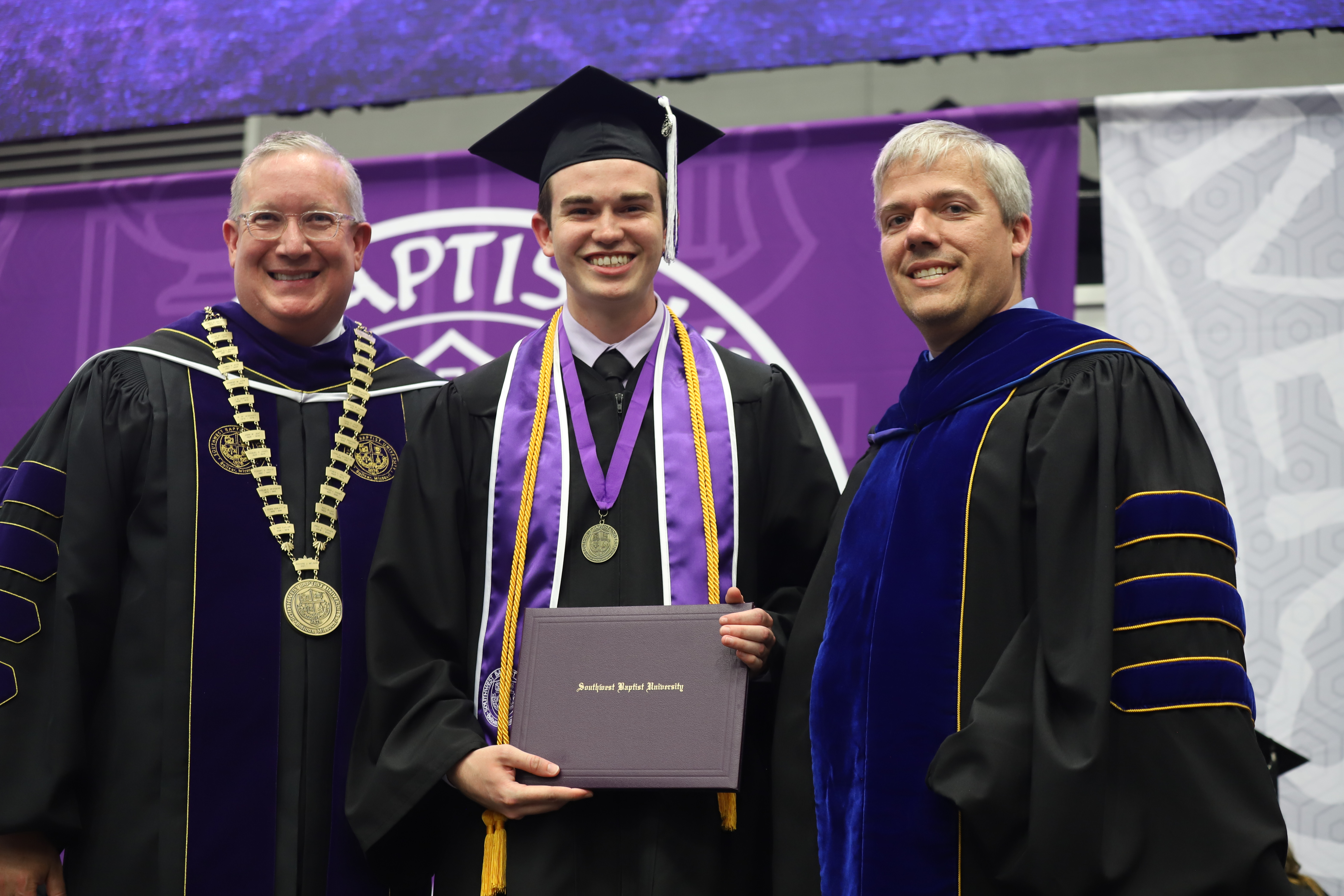 President Rick Melson, Tyler Eads, and Provost Lee Skinkle pose for photo after Tyler is presented with award