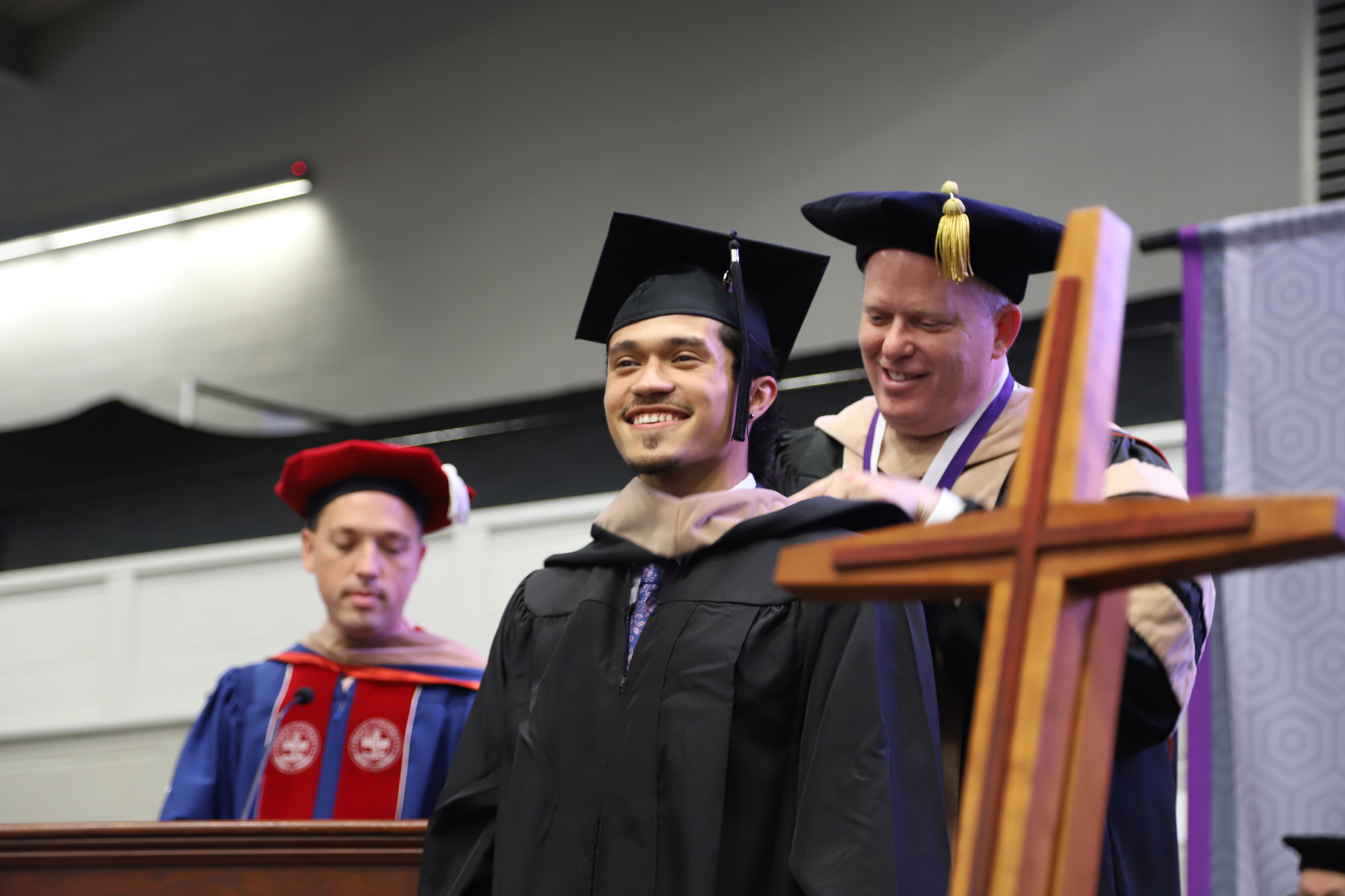 Male graduate receives M-B-A hood during commencement ceremony