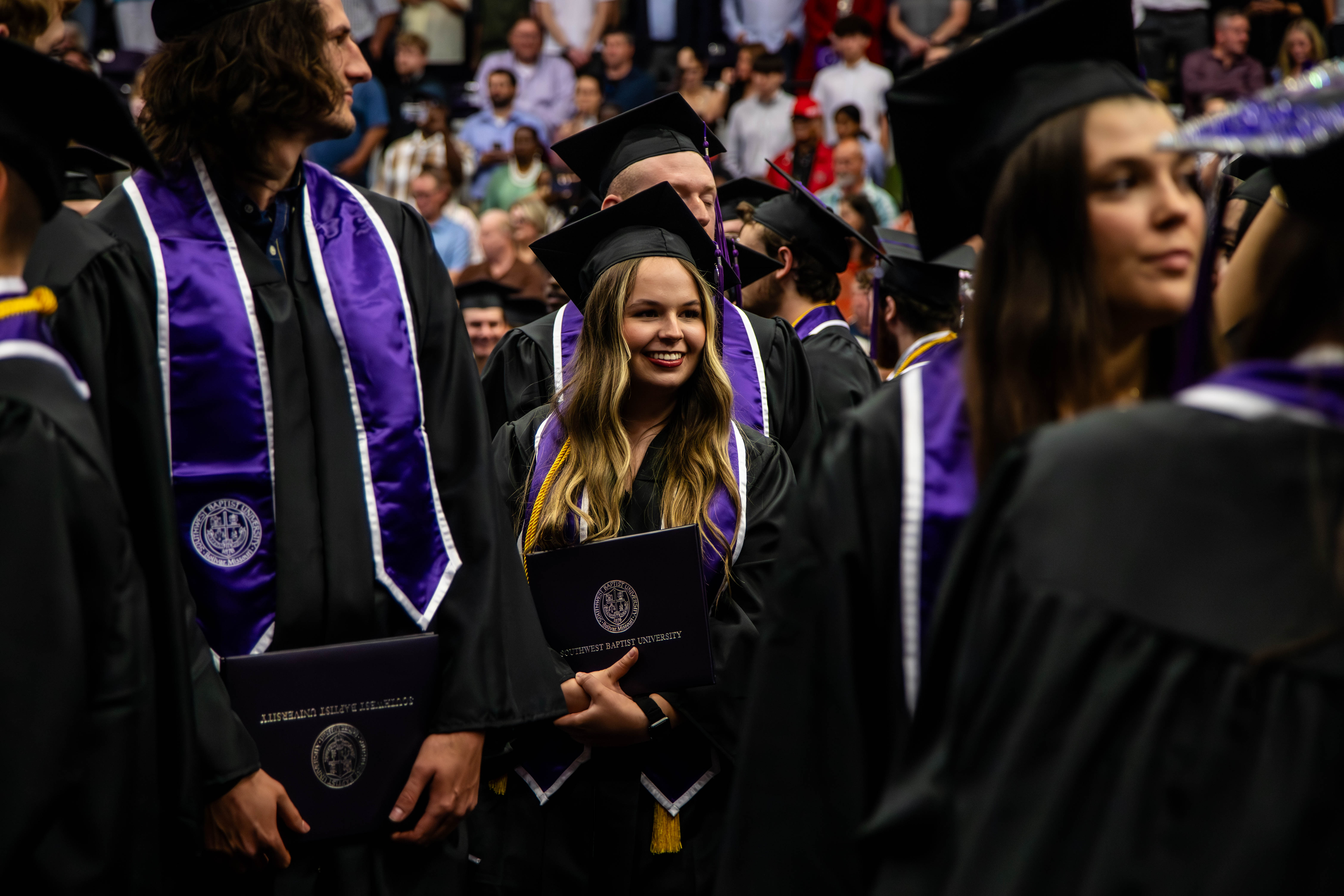 Female student holding diploma at SBU commencement 2026.