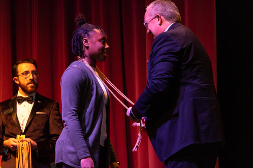 Rachel Tippens receives honors cords from Dr. Rick Melson