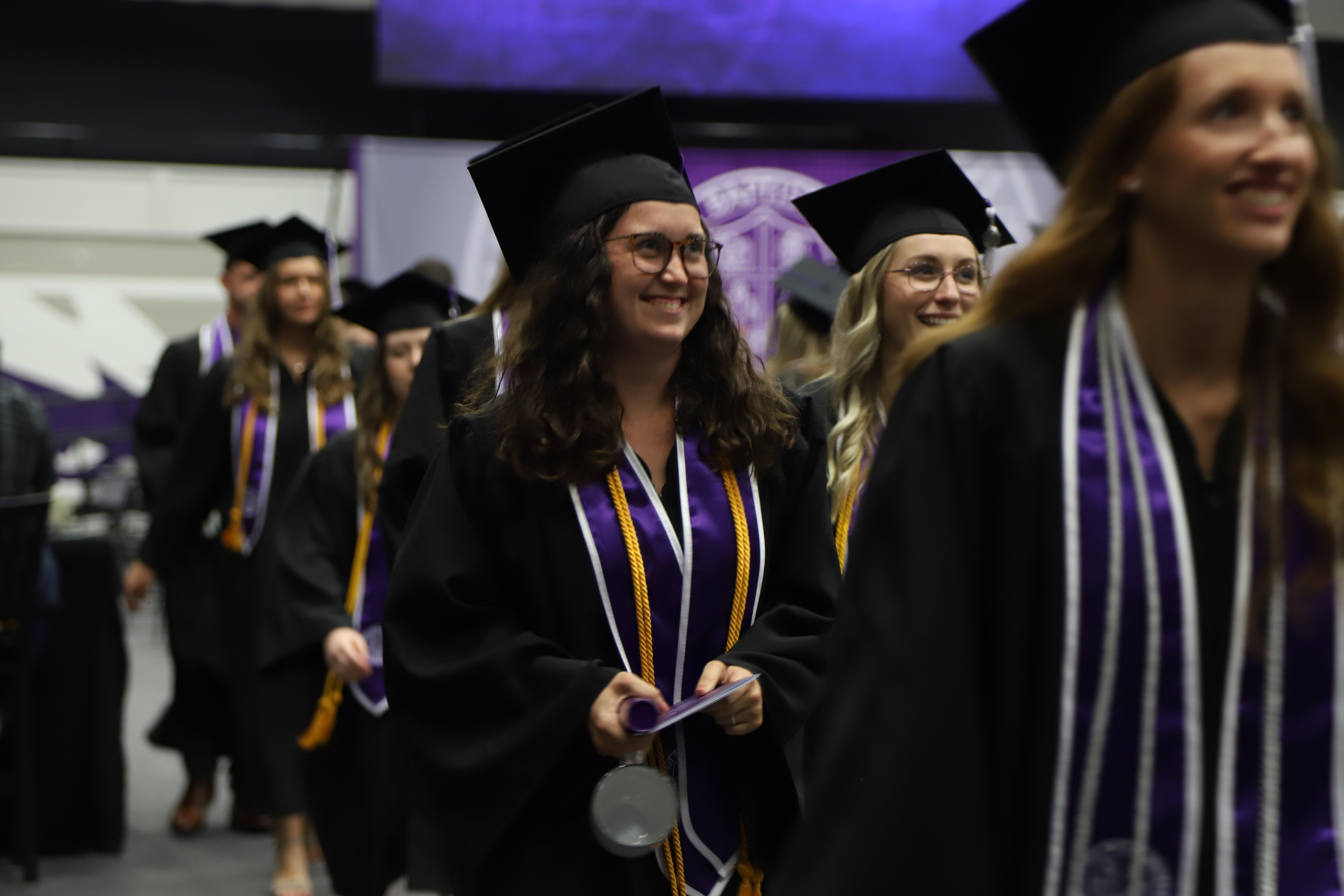Students smile as they leave the graduation ceremony