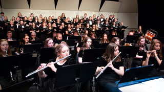 Instrumental and choral ensembles perform on stage together