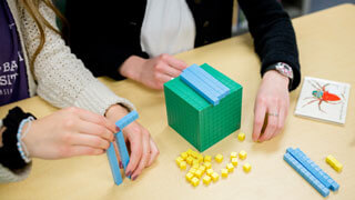 close up of students' hands as they work with math manipulative blocks