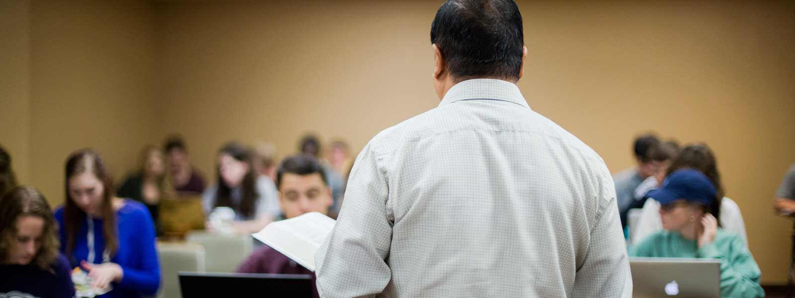 view from behind professor as he lectures to class