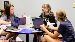 group of communication students talking and laughing