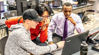 student working on laptop sitting at desk