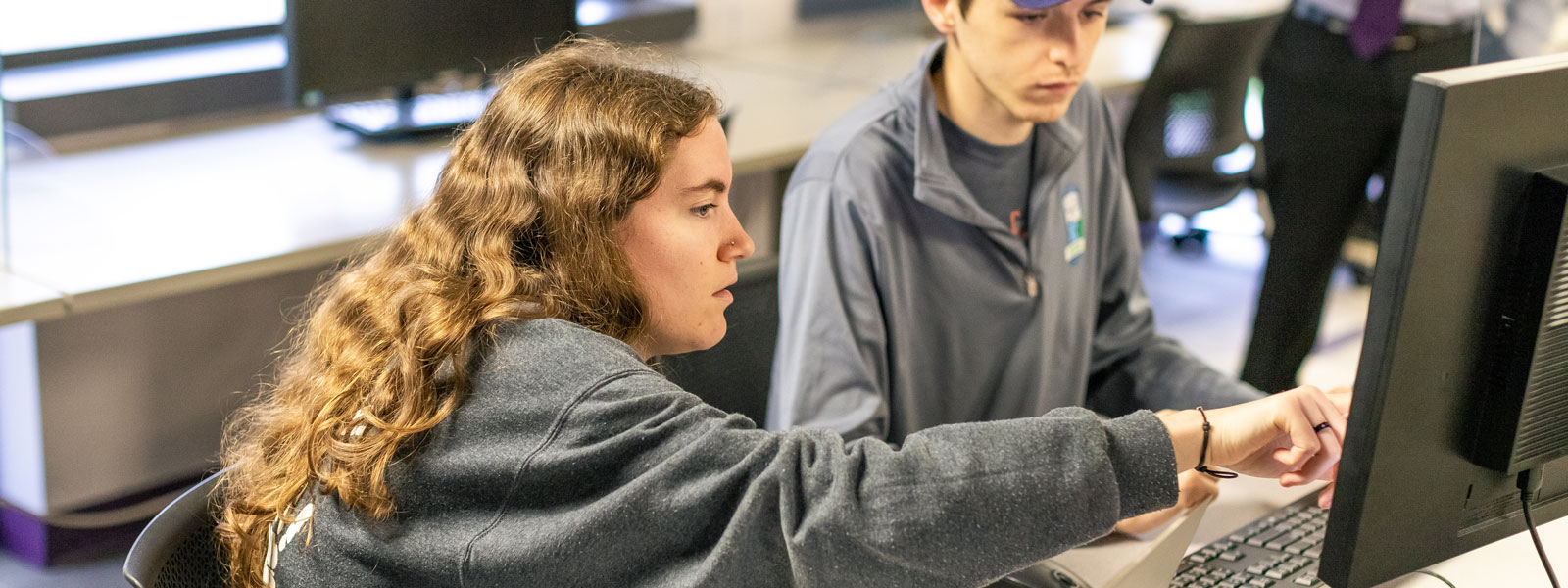 students looking at laptop screen in discussion group