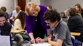 two students look at book in library