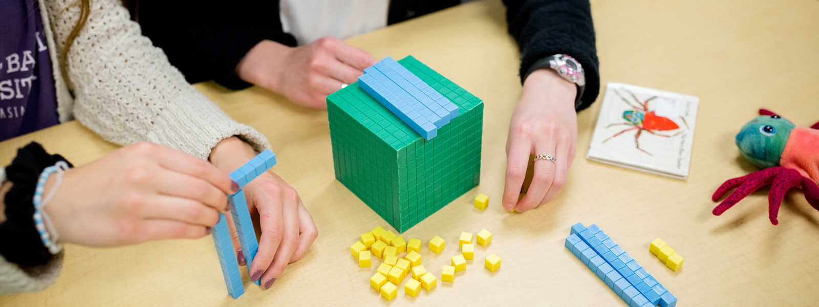 close-up of students' hands as they work with math manipulative blocks
