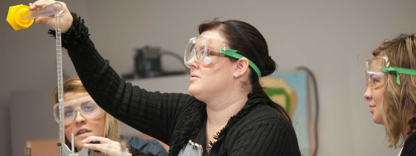 student works on chemistry experiment wearing goggles