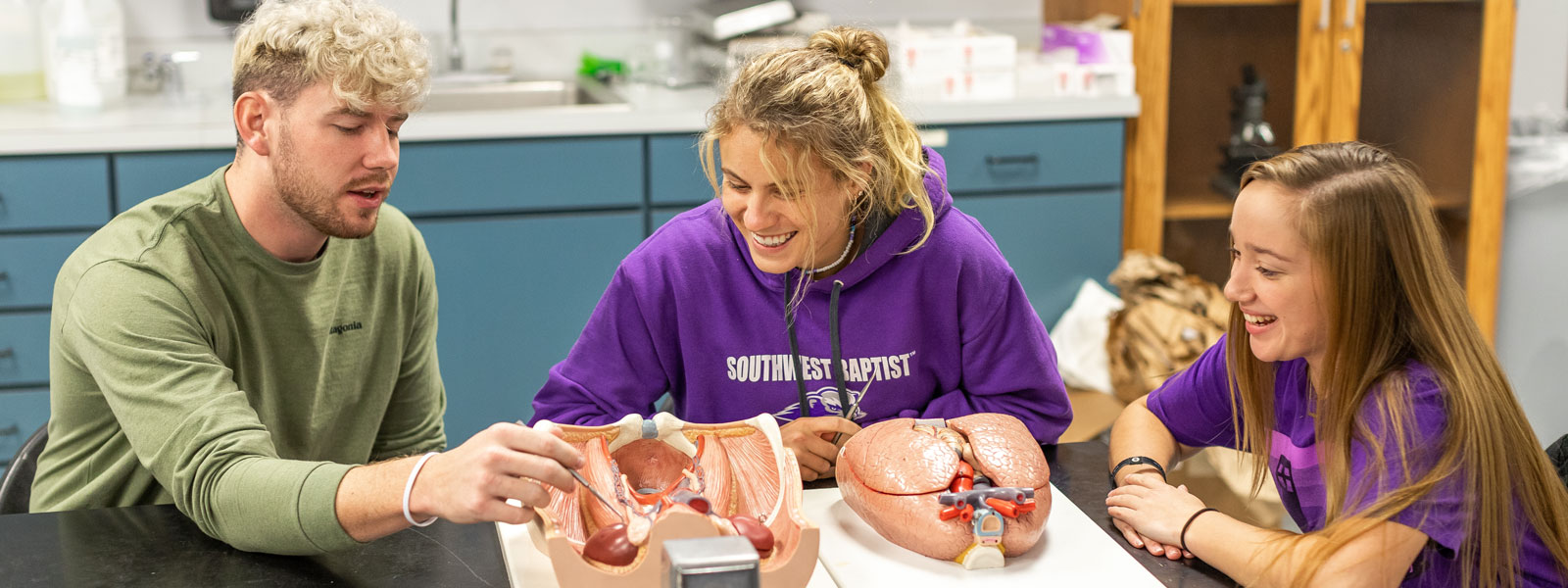 biology professor and students examine molecule example in lab