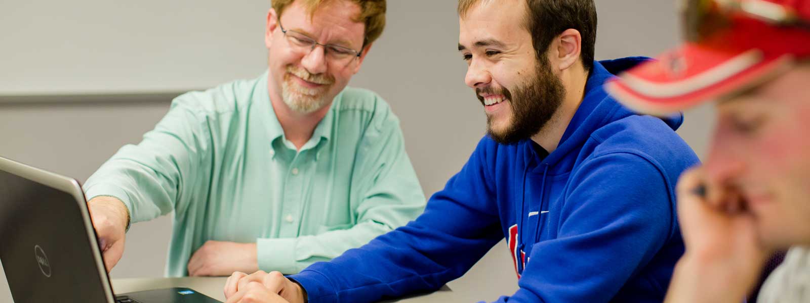 professor points to computer screen while helping student