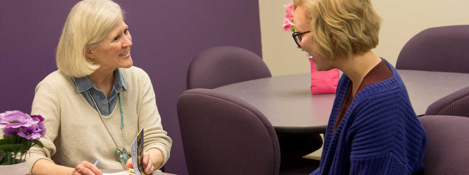 visiting author chats with female college student in Writing Center