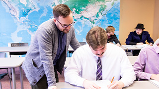 professor offering help to a global education student