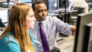 professor works with student at a computer