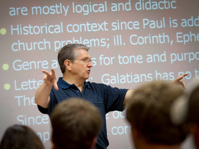 Professor in front of projector teaching class