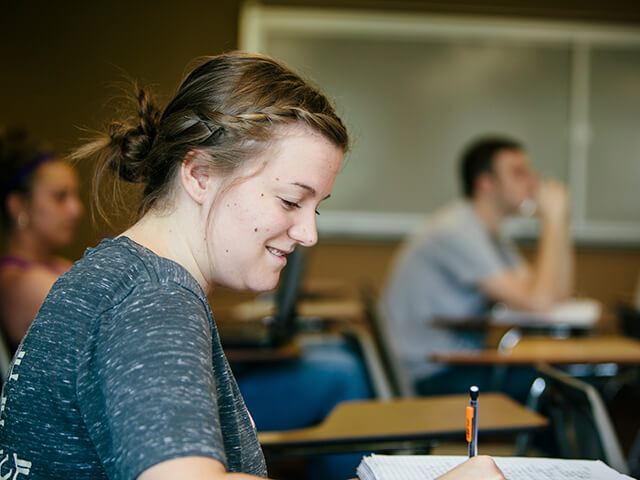 Female student takes notes in class