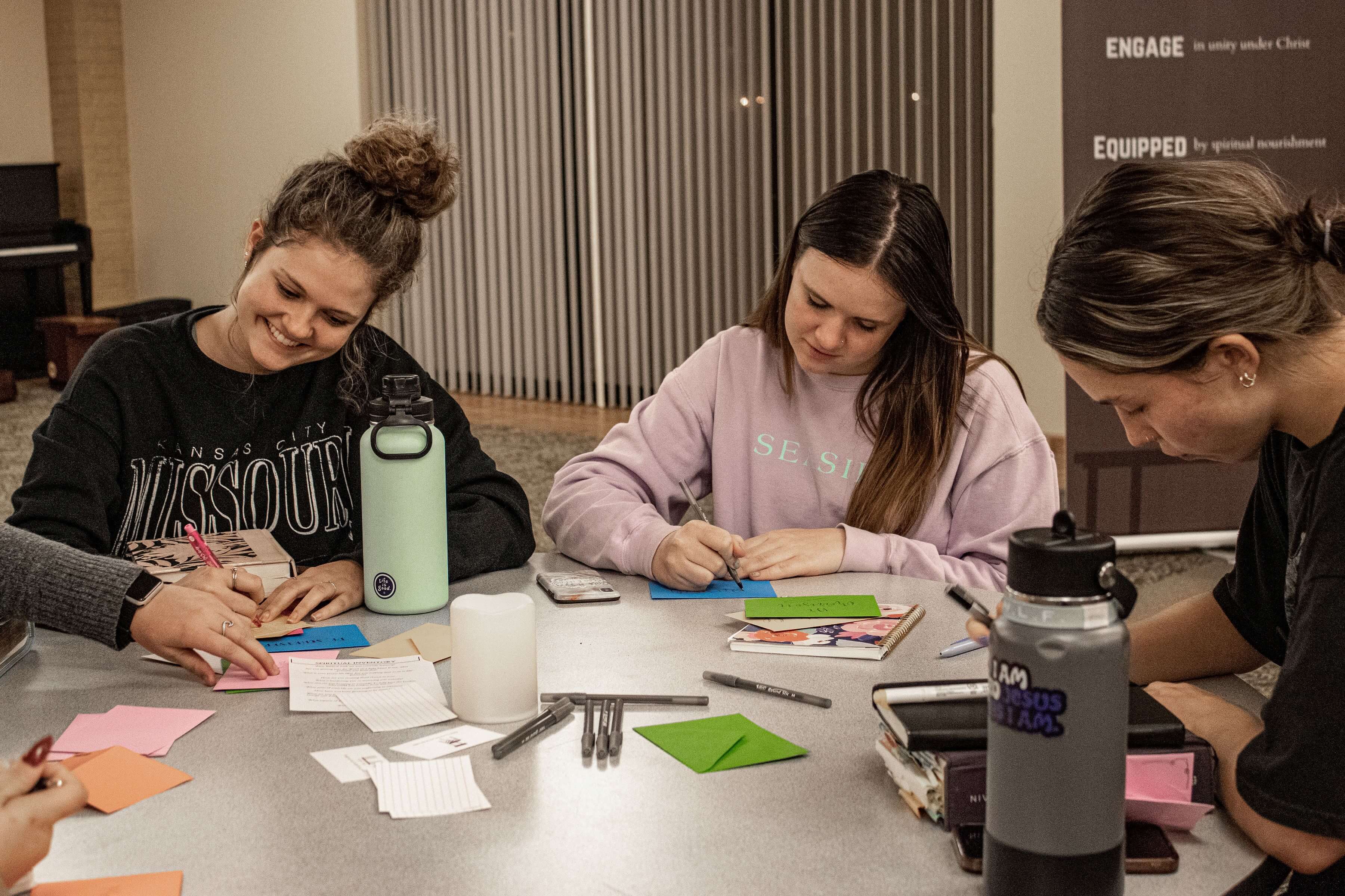 a small group participates in a card making activity at The Table